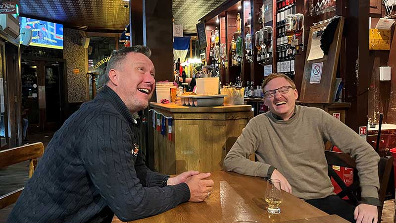 Tv� glada resen�rer njuter av skotsk pubkultur med whisky och skratt � whiskyresan g�r med Tj�rnarpsbuss